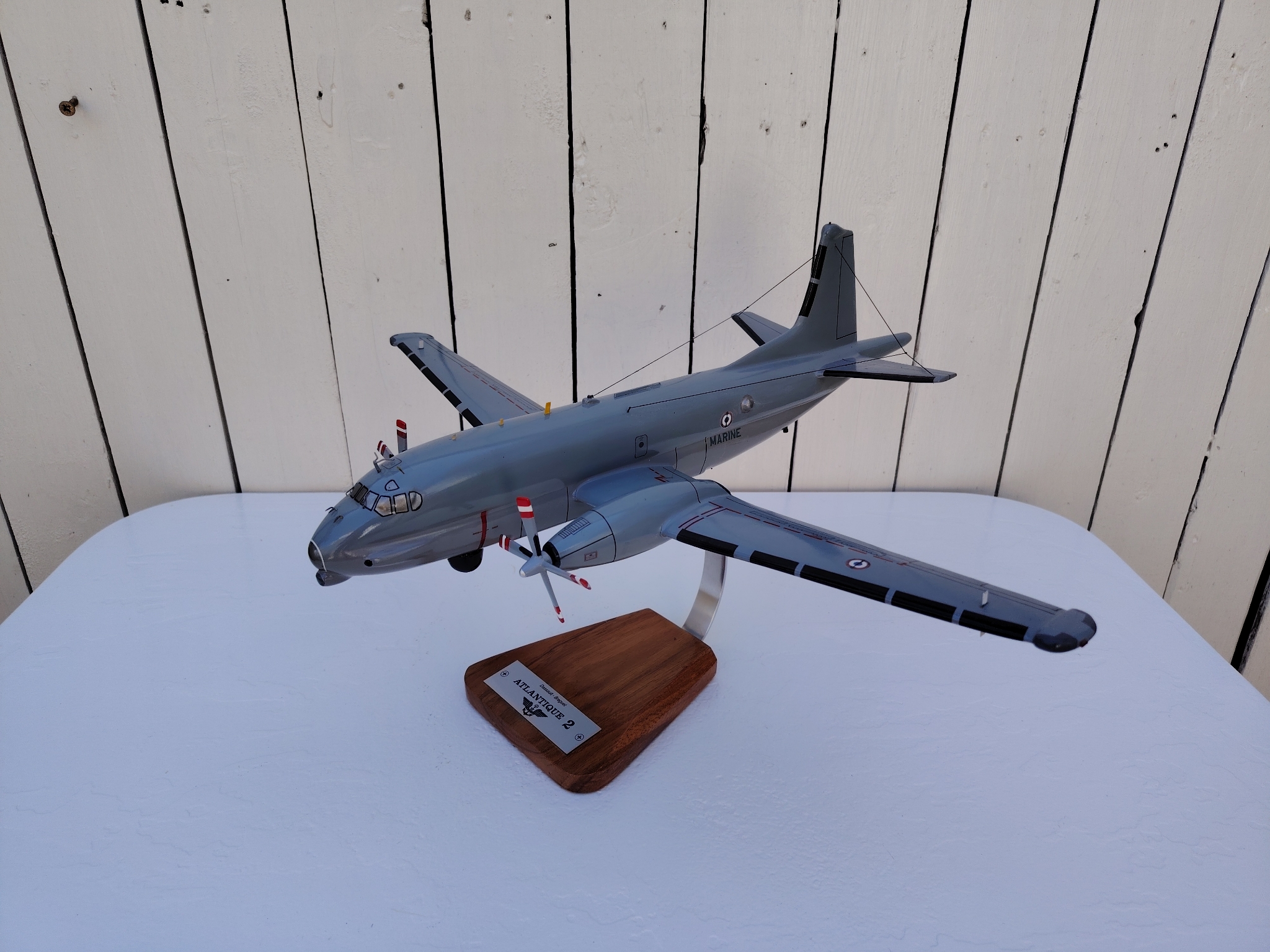 Maquette avion de la marine Française. Modèle: Atlantique 2 Réalisation en bois massif, sculptée et peinte à la main. Sur socle en Acacia vernis avec plaquette gravée. De la marque Pilot station Petites traces et rayures d'usage. Bon état général Dimensions : 45 x 50 x 27 cm