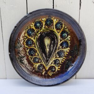 Assiette décorative en céramique émaillée au décor central à la forme de fleur. Signée sur le dessous A.N. Un petit éclat sur le rebord. Bon état général. Diamètre : 27 cm