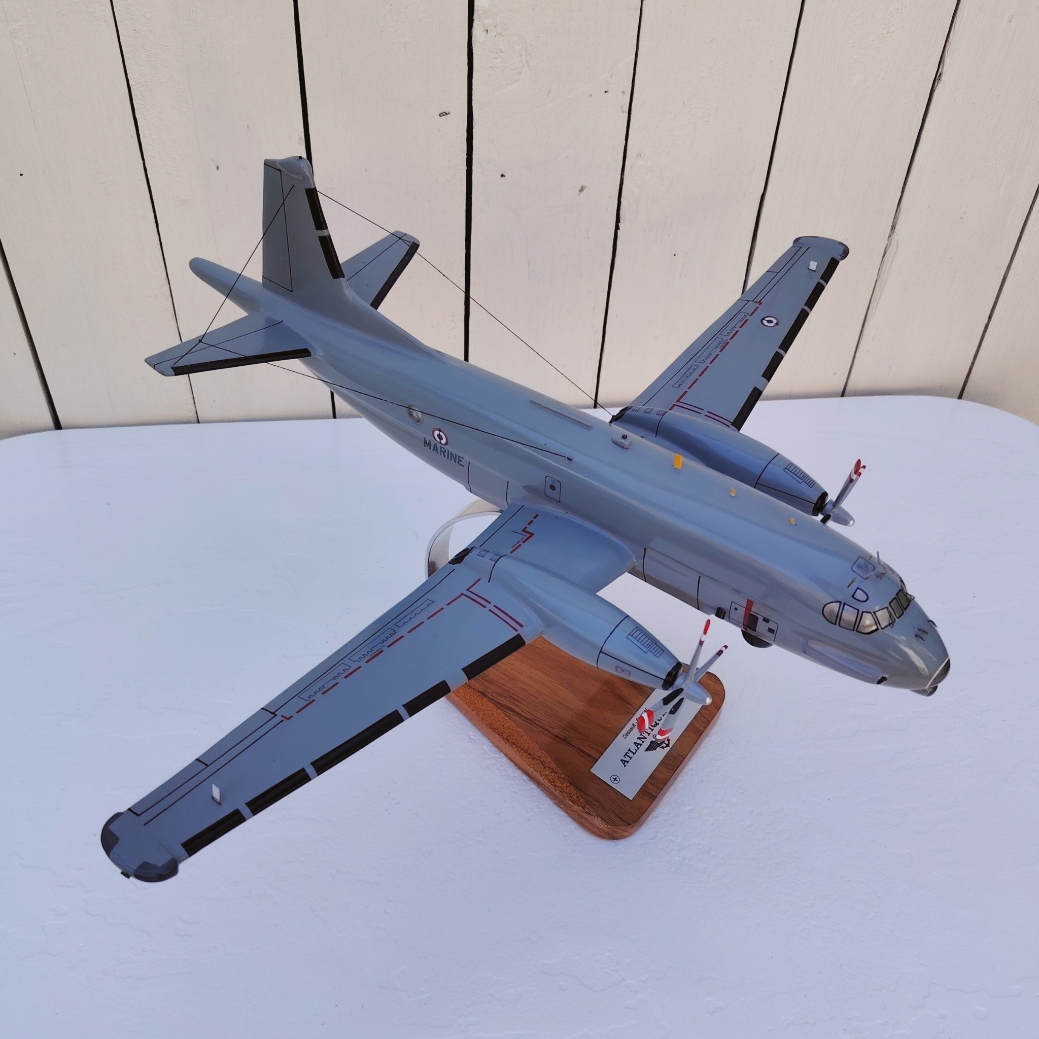 Maquette avion de la marine Française. Modèle: Atlantique 2 Réalisation en bois massif, sculptée et peinte à la main. Sur socle en Acacia vernis avec plaquette gravée. De la marque Pilot station Petites traces et rayures d'usage. Bon état général Dimensions : 45 x 50 x 27 cm