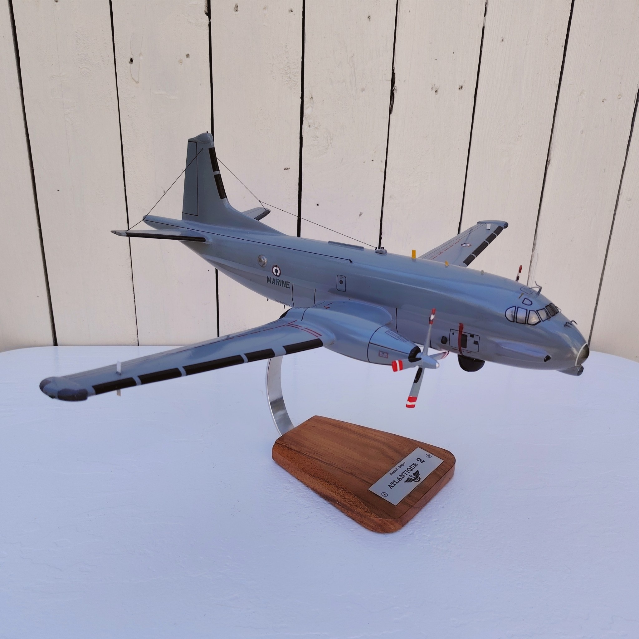 Maquette avion de la marine Française. Modèle: Atlantique 2 Réalisation en bois massif, sculptée et peinte à la main. Sur socle en Acacia vernis avec plaquette gravée. De la marque Pilot station Petites traces et rayures d'usage. Bon état général Dimensions : 45 x 50 x 27 cm