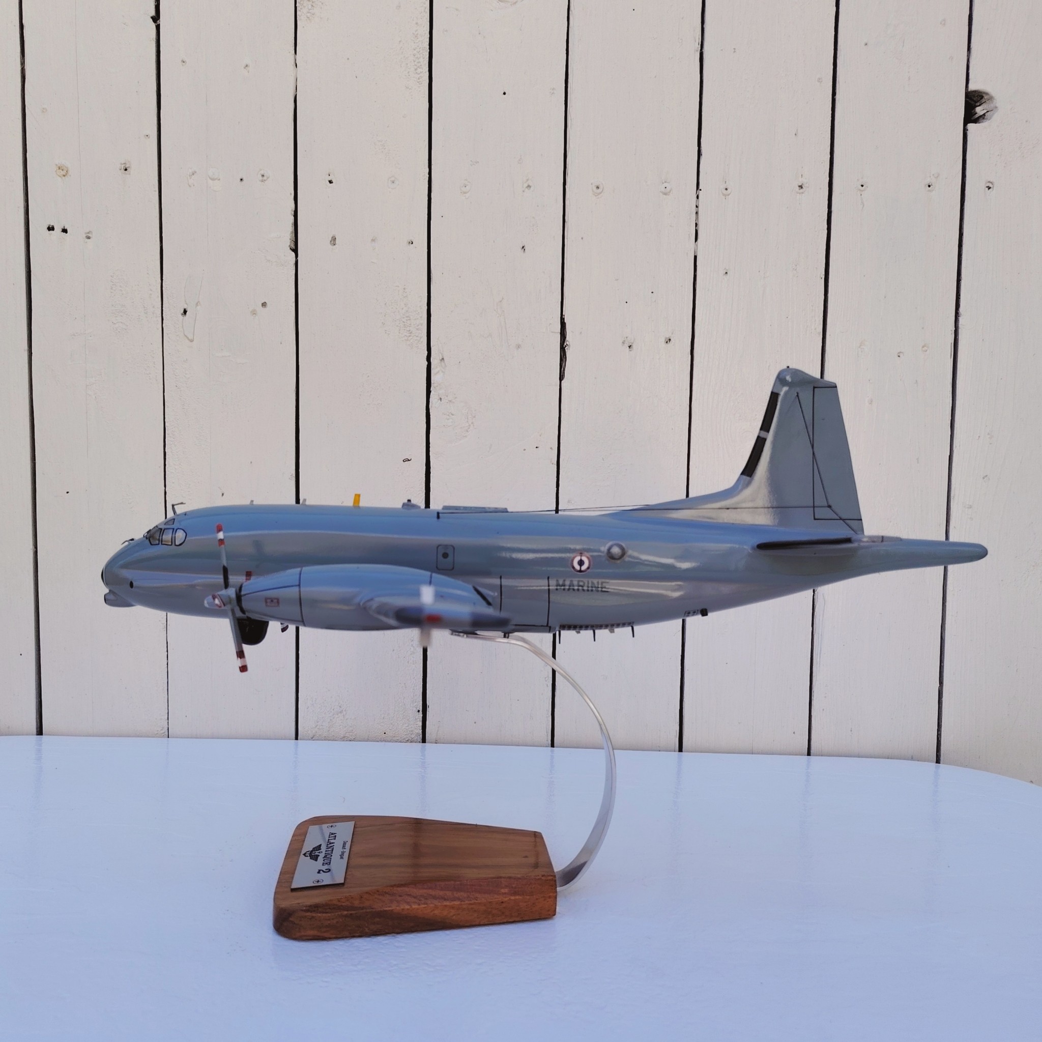 Maquette avion de la marine Française. Modèle: Atlantique 2 Réalisation en bois massif, sculptée et peinte à la main. Sur socle en Acacia vernis avec plaquette gravée. De la marque Pilot station Petites traces et rayures d'usage. Bon état général Dimensions : 45 x 50 x 27 cm