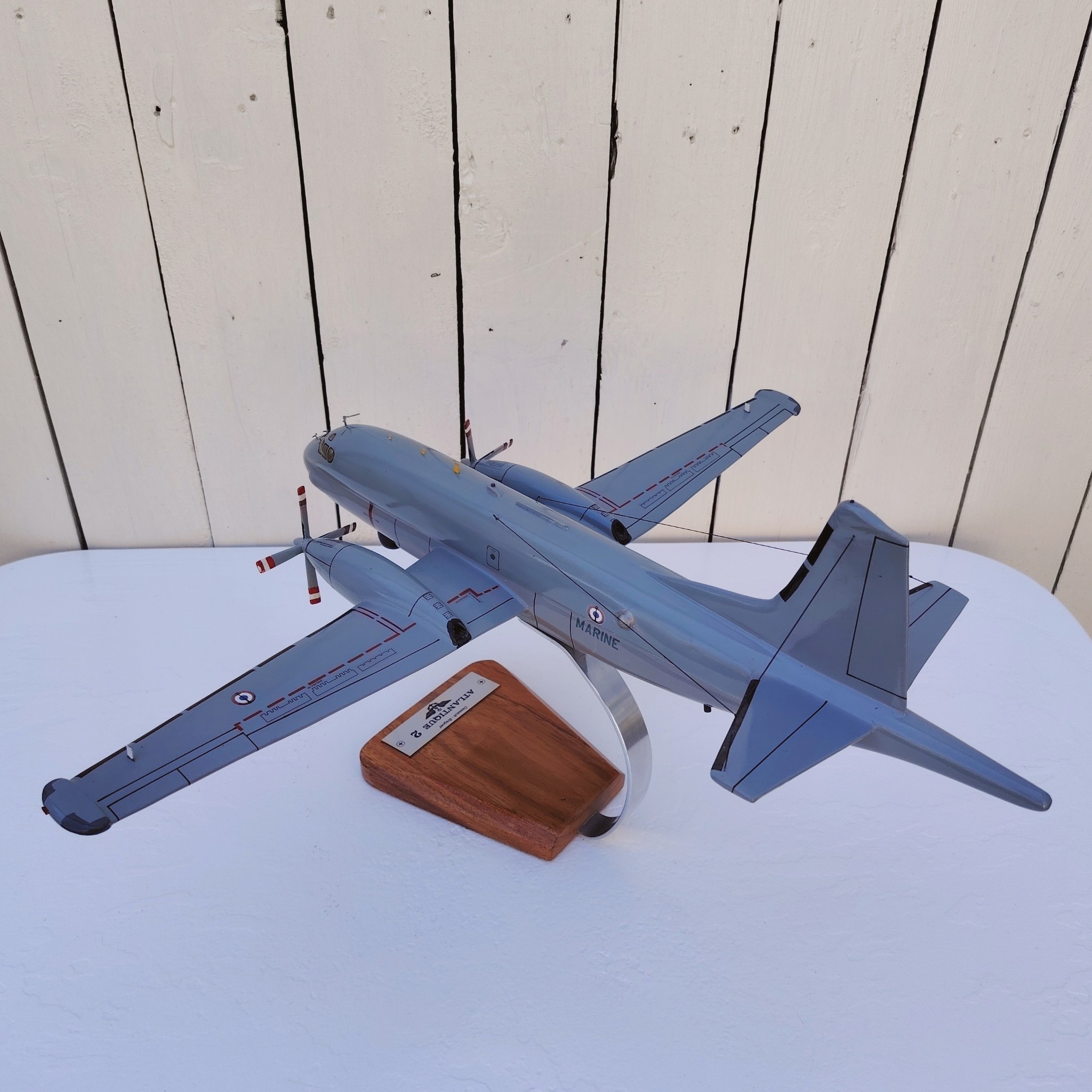 Maquette avion de la marine Française. Modèle: Atlantique 2 Réalisation en bois massif, sculptée et peinte à la main. Sur socle en Acacia vernis avec plaquette gravée. De la marque Pilot station Petites traces et rayures d'usage. Bon état général Dimensions : 45 x 50 x 27 cm