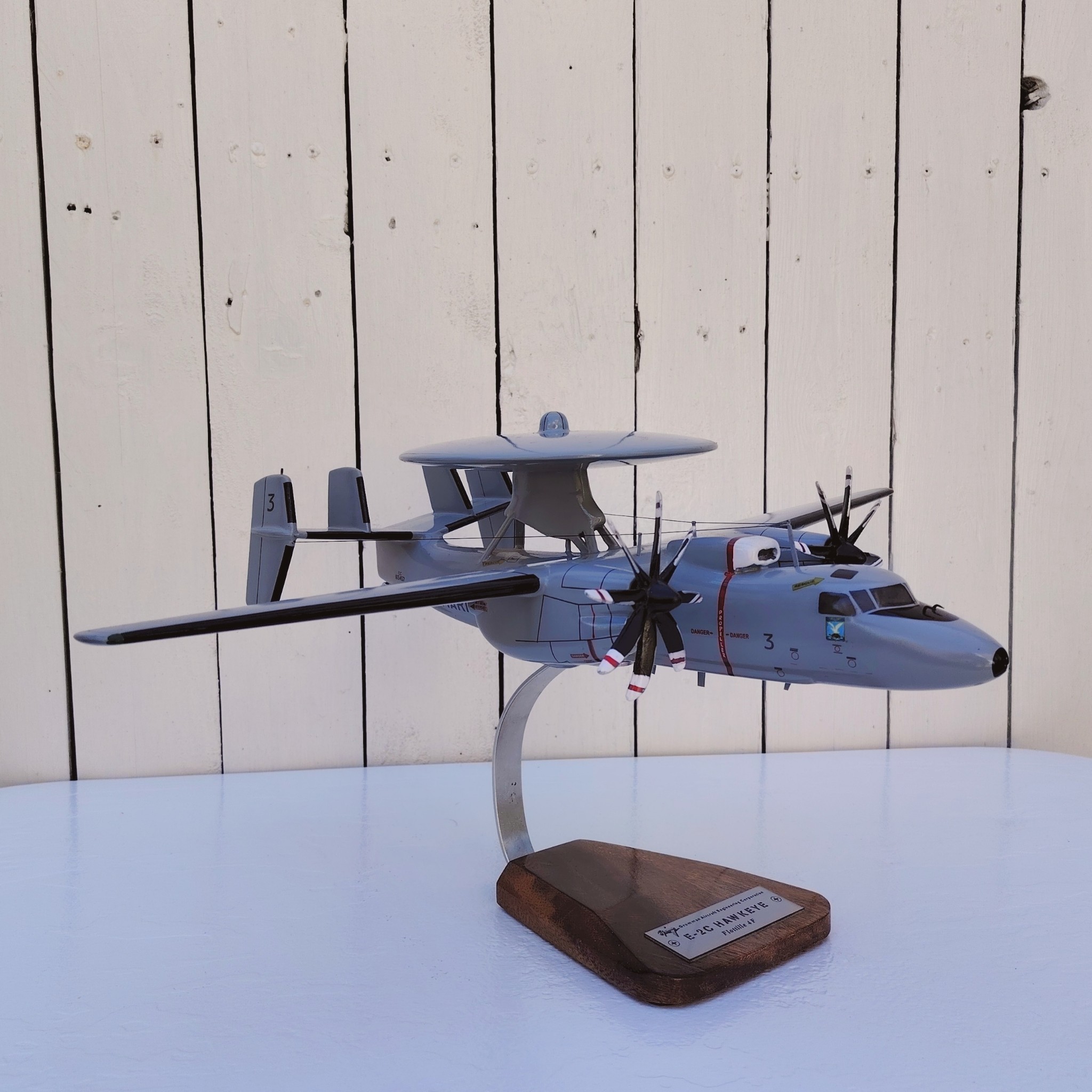 Maquette avion aux couleurs de la Flottille 4F de l'Aéronavale Française. Modèle: E2C-Hawkeye, Réalisation en bois massif, sculptée et peinte à la main. Sur socle en Acacia vernis avec plaquette gravée. De la marque Pilot station. Petites traces et rayures d'usage. Bon état général Dimensions : 37x49x 24 cm