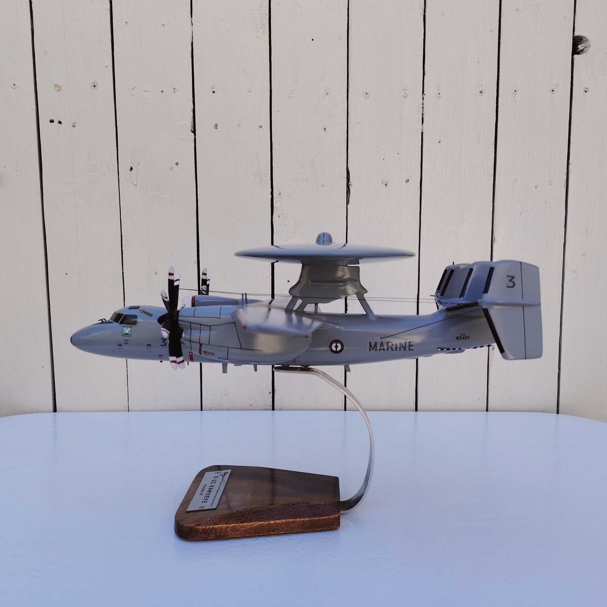 Maquette avion aux couleurs de la Flottille 4F de l'Aéronavale Française. Modèle: E2C-Hawkeye, Réalisation en bois massif, sculptée et peinte à la main. Sur socle en Acacia vernis avec plaquette gravée. De la marque Pilot station. Petites traces et rayures d'usage. Bon état général Dimensions : 37x49x 24 cm