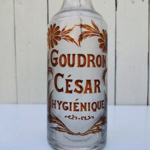 Ancienne carafe publicitaire en verre soufflé pour la liqueur appelée " Goudron hygiénique" distribuée par le bistrot César.  Alcool très apprécié au début XXéme pour ses vertus bienfaisantes. Trace de calcaire. Bon état général Hauteur : 28 cm