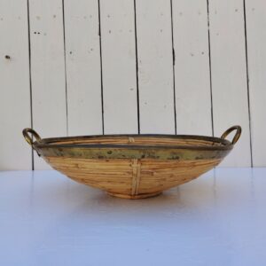 Corbeille ou centre de table en rotin finissant par un col en laiton doré, faisant penser au travail de Gabriella Crespi. Petites usures du rotin sans gravité , traces d'oxydation sur le laiton. Bon état général Hauteur : 11 cm Diamètre : 39 cm