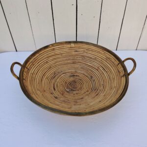 Corbeille ou centre de table en rotin finissant par un col en laiton doré, faisant penser au travail de Gabriella Crespi. Petites usures du rotin sans gravité , traces d'oxydation sur le laiton. Bon état général Hauteur : 11 cm Diamètre : 39 cm