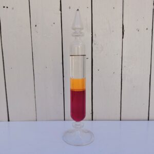 Tube en verre décoratif  datant des années 70, remplit partiellement de trois liquides qui permettent une fois mélangés de comprendre la question de la densité des éléments liquide. Bel objet décoratif , très space age, pop. Très bon état. Hauteur : 34 cm