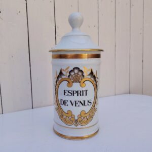 Grand pot d'apothicaire en porcelaine de Limoges.  Inscription : " Esprit de Vénus" Petit manque de  dorure sur le contour du couvercle. Très bon état Hauteur avec couvercle :  28 cm Diamètre : 11 cm