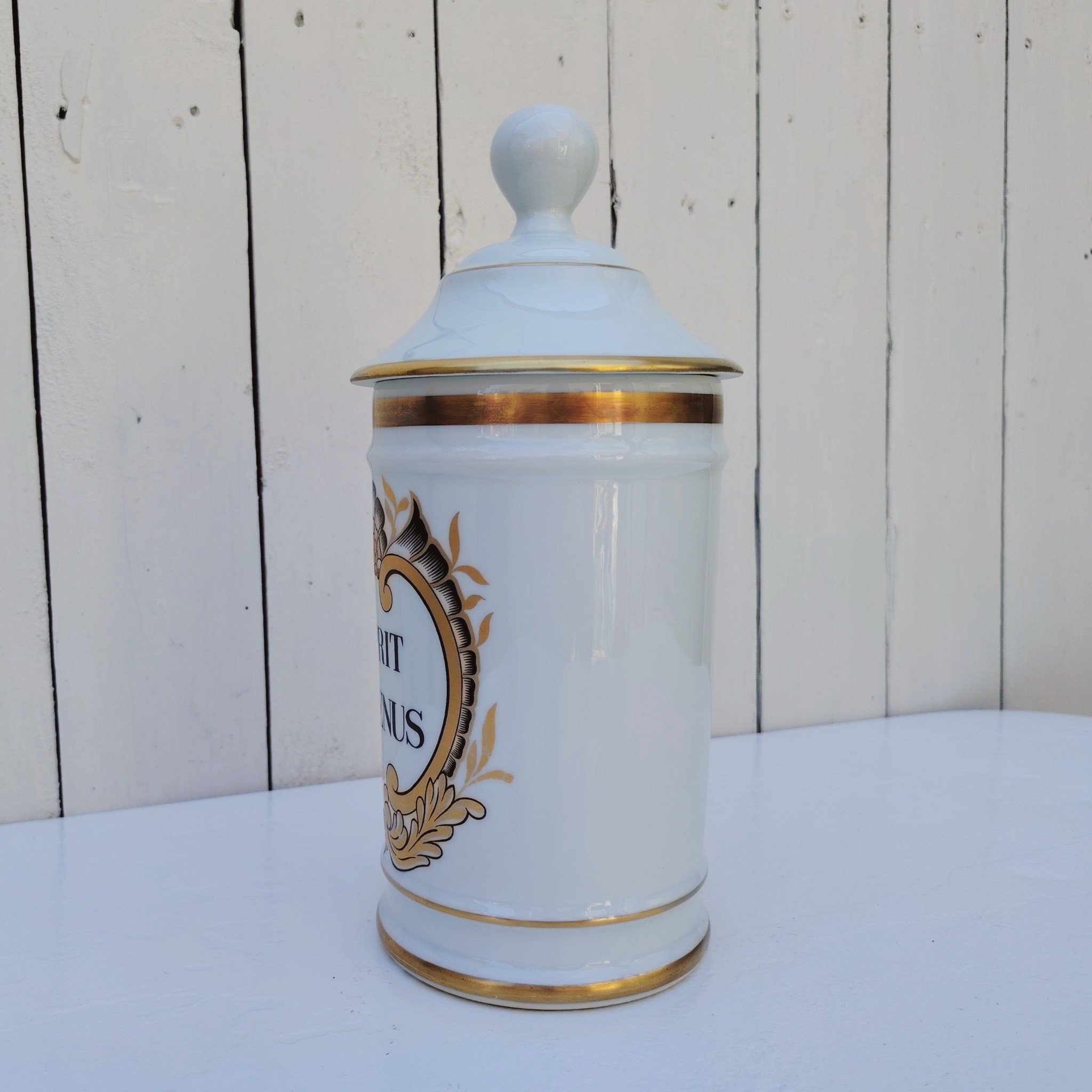 Grand pot d'apothicaire en porcelaine de Limoges.  Inscription : " Esprit de Vénus" Petit manque de  dorure sur le contour du couvercle. Très bon état Hauteur avec couvercle :  28 cm Diamètre : 11 cm