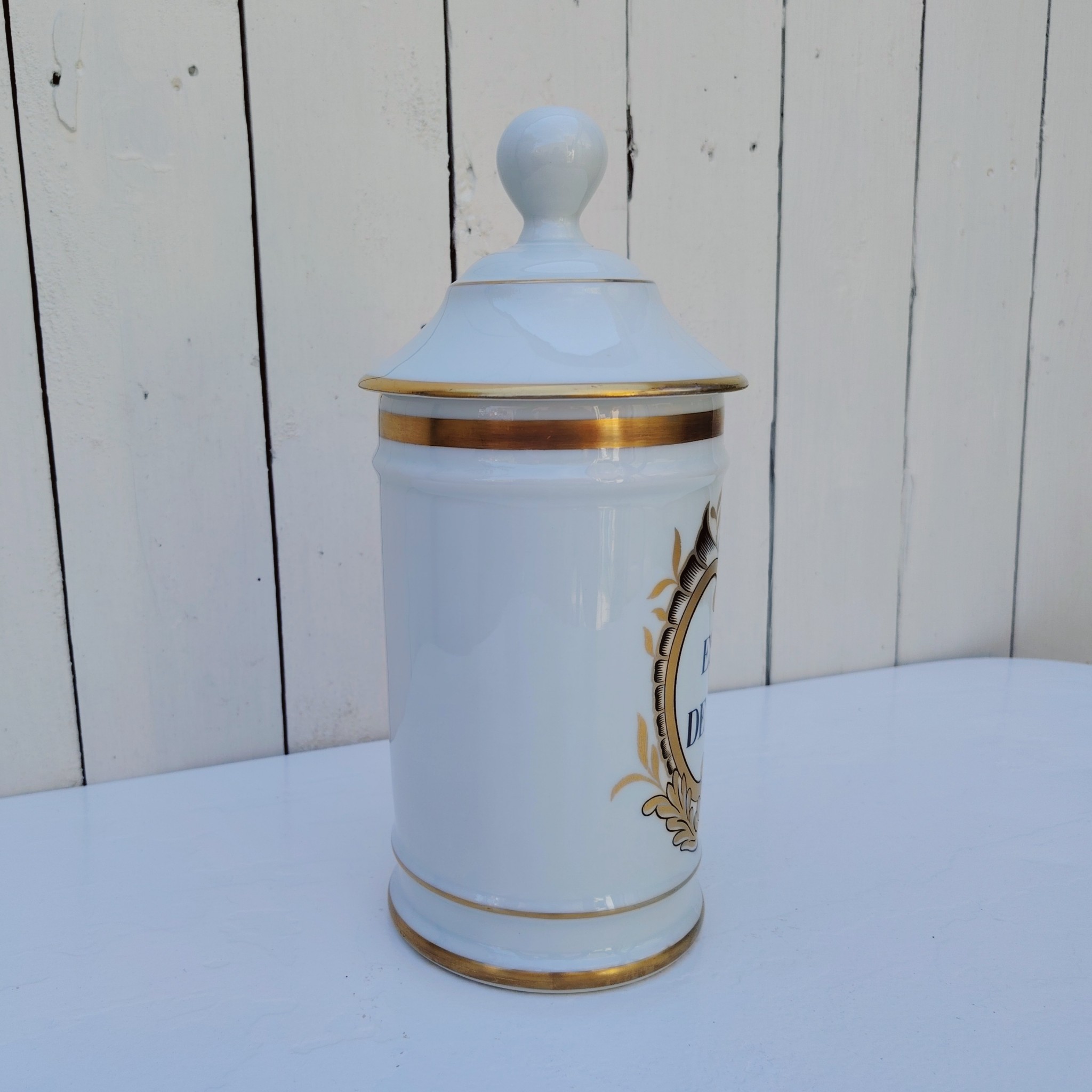 Grand pot d'apothicaire en porcelaine de Limoges.  Inscription : " Esprit de Vénus" Petit manque de  dorure sur le contour du couvercle. Très bon état Hauteur avec couvercle :  28 cm Diamètre : 11 cm