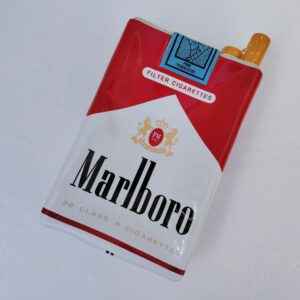 Grand vide poche en céramique représentant un paquet de cigarettes de la marque Marlboro. Petites rayures et traces d'usage sans gravité. Bon état général. Dimensions : 33 x 18 x 7 cm