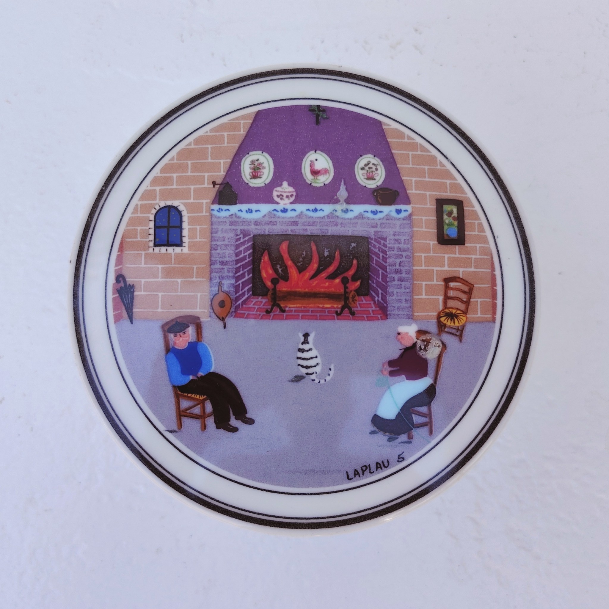 Boite en porcelaine Villeroy & Boch, décor naïf par Laplau. Décor d'un couple au coin du feu. Excellent état. Hauteur : 5 cm Diamètre : 10,5 cm