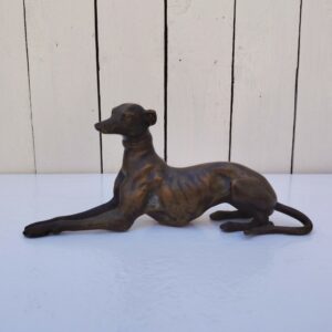 Sculpture en bronze représentant un lévrier en position du sphinx, belle patine mordorée. Belle définition des détails. Traces d'usage Bon état général . Dimensions : 23 x 7 x 10 cm