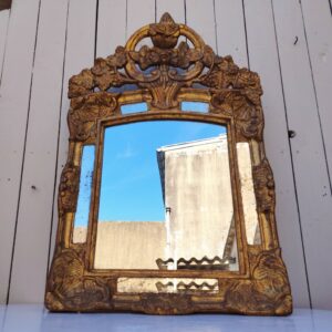 Miroir italien reproduisant de style régence, en bois doré et parcloses. Epoque XXème. Piqûre des tains des parcloses. manque de dorures. Bon état général 81 x 53 cm