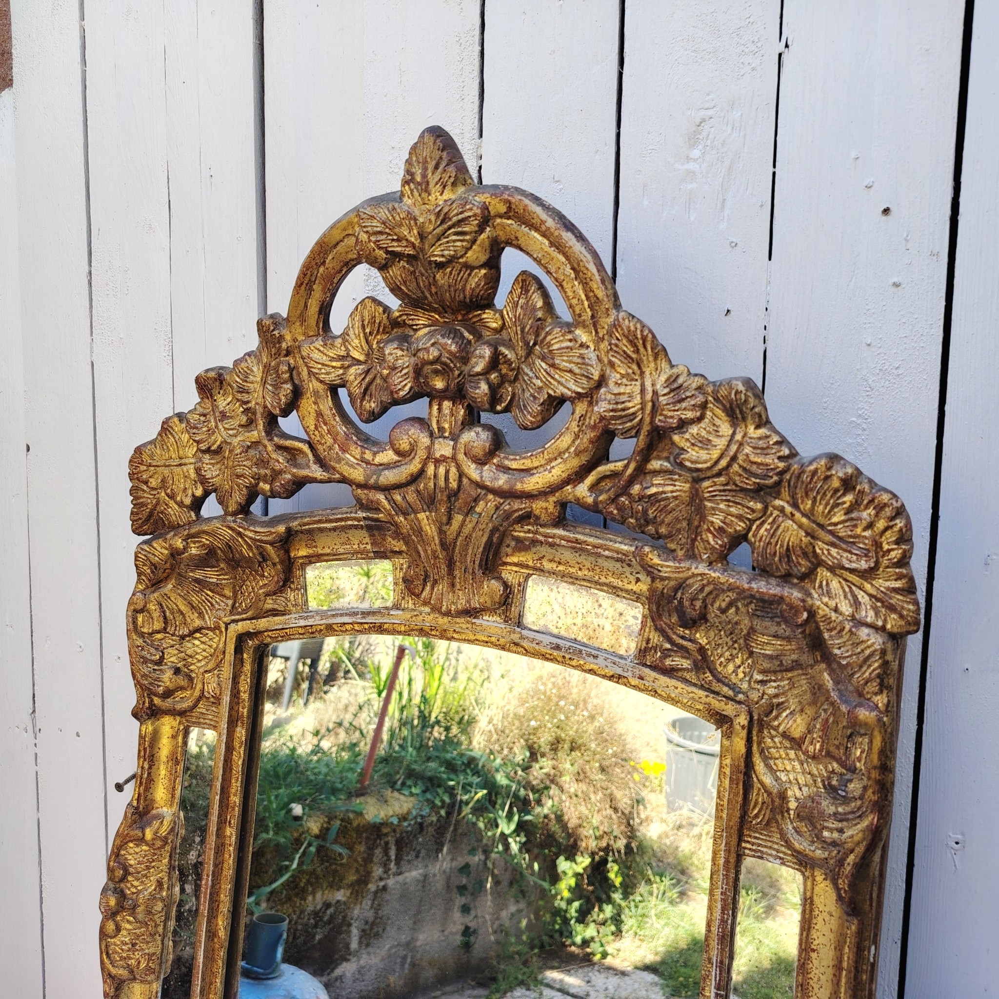 Miroir italien reproduisant de style régence, en bois doré et parcloses. Epoque XXème. Piqûre des tains des parcloses. manque de dorures. Bon état général 81 x 53 cm