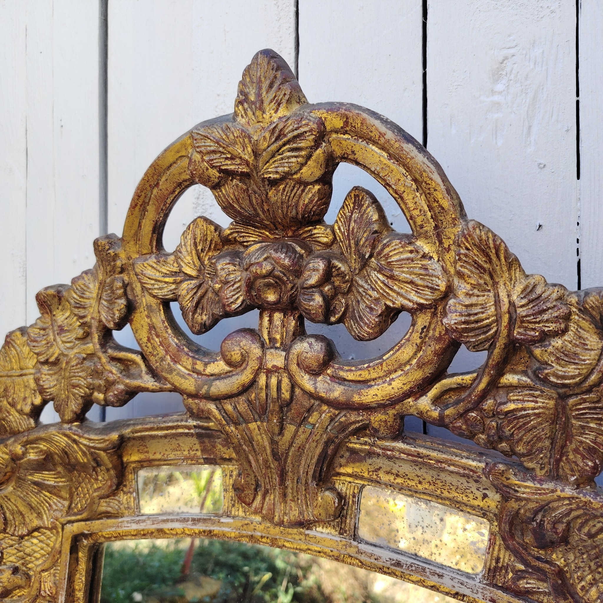 Miroir italien reproduisant de style régence, en bois doré et parcloses. Epoque XXème. Piqûre des tains des parcloses. manque de dorures. Bon état général 81 x 53 cm
