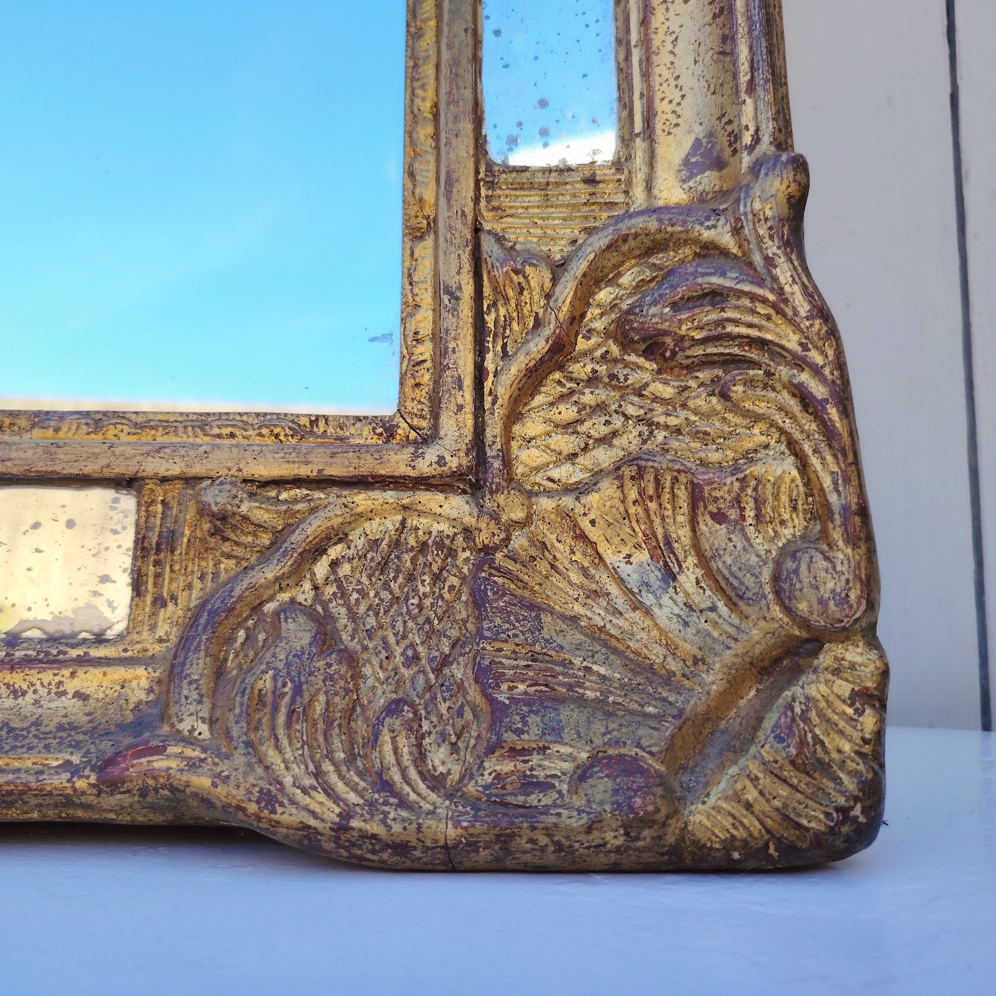 Miroir italien reproduisant de style régence, en bois doré et parcloses. Epoque XXème. Piqûre des tains des parcloses. manque de dorures. Bon état général 81 x 53 cm