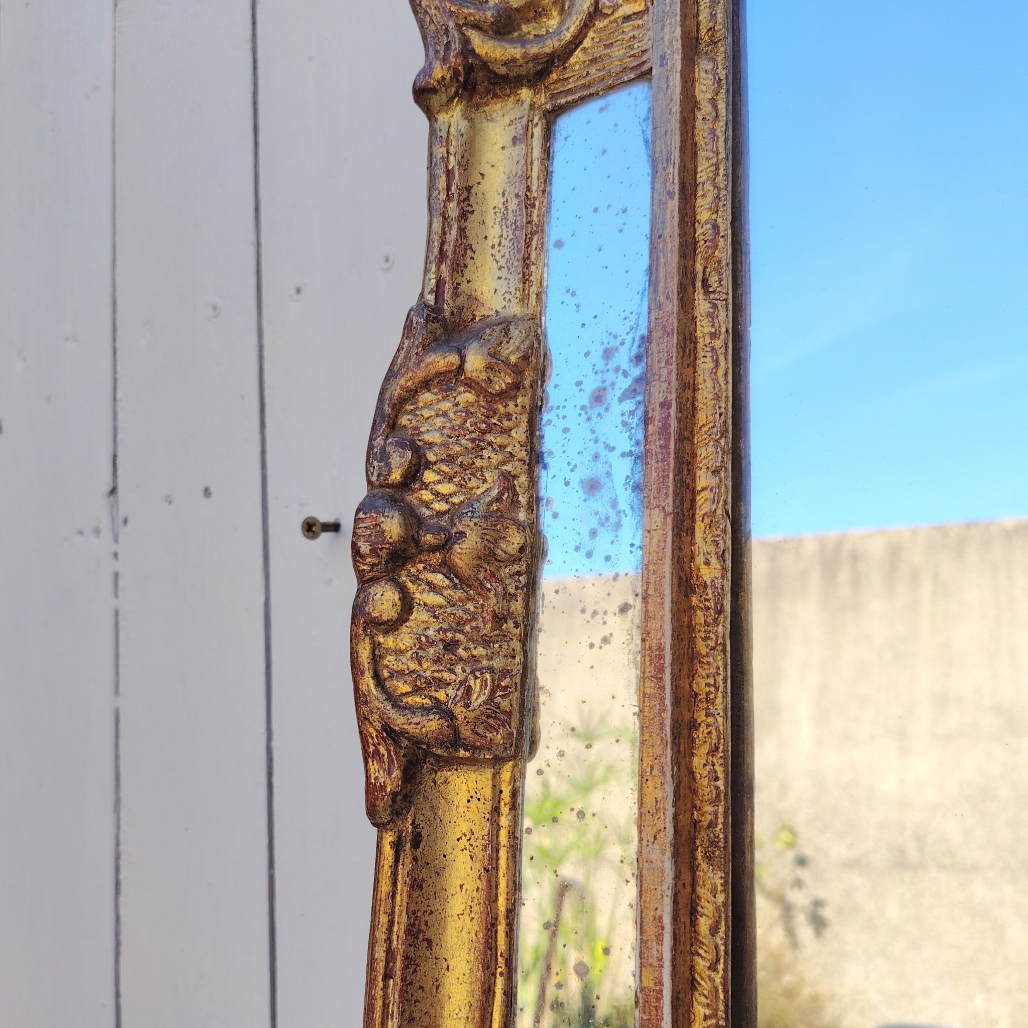 Miroir italien reproduisant de style régence, en bois doré et parcloses. Epoque XXème. Piqûre des tains des parcloses. manque de dorures. Bon état général 81 x 53 cm