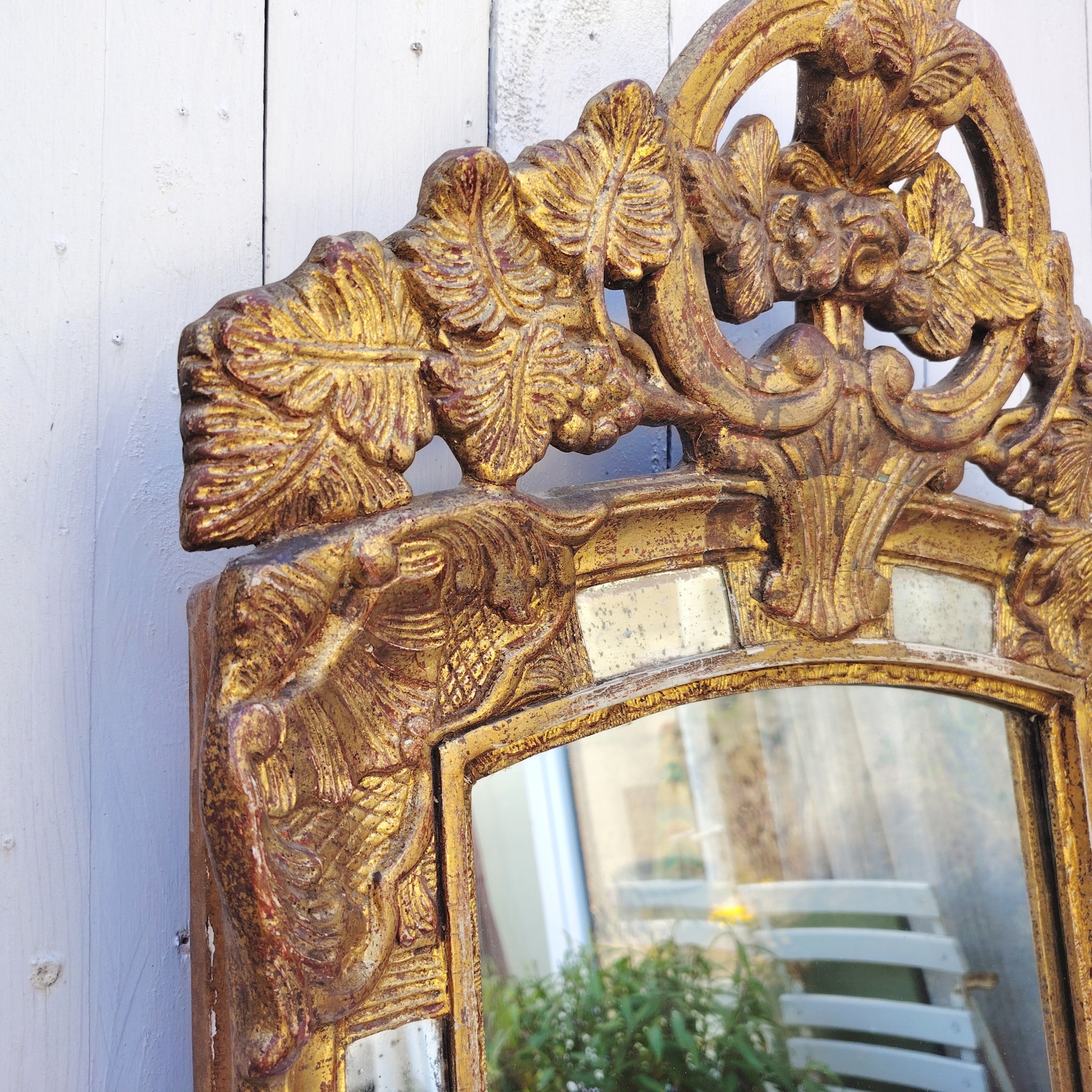 Miroir italien reproduisant de style régence, en bois doré et parcloses. Epoque XXème. Piqûre des tains des parcloses. manque de dorures. Bon état général 81 x 53 cm