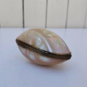 Œuf décoratif en nacre naturelle, monté sur une monture ciselé à décor perlé. Pouvant servir de petite boite à bijoux comme des bagues ou alors porte chapelet qui devait être sa première destination. Beaux reflets irisés . Bon état général Dimensions fermé : 9,5 x 5 x 6,5 cm