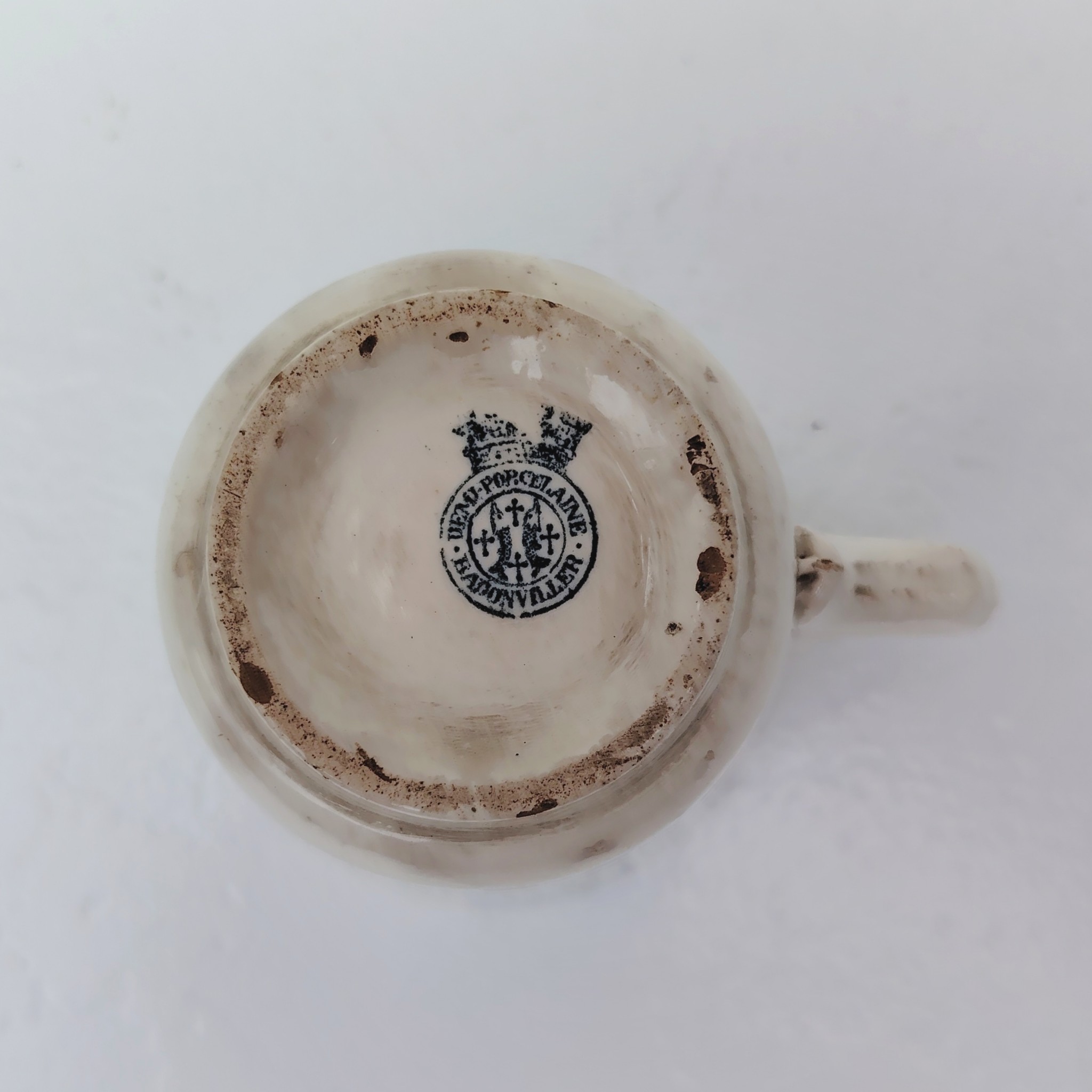 Rare tasse publicitaire VIANDOX en demi-porcelaine de Badonviller, ornée du slogan « La Santé par Viandox ! Produit Liebig ». Décor bleu-vert, encadré de guirlandes végétales Cachet de la faïencerie de Badonviller sur le dessous, identifiable à sa marque à la couronne, confirmant une fabrication française vers 1920. Des petites égrenures sur le col Bon état général Hauteur : 8 cm Diamètre : 8,5 cm